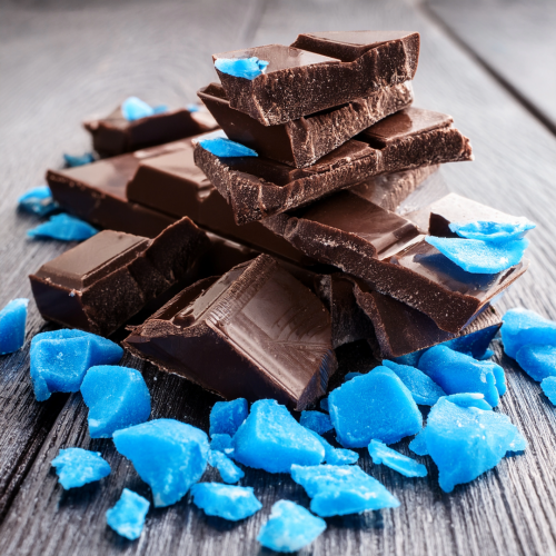 Dark chocolate on counter with blue candy pieces