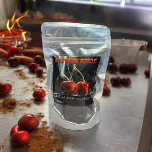 afterburn brickle bag on counter with cherries, spices and fire in background
