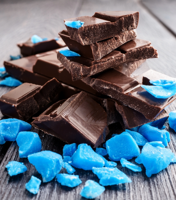 Dark chocolate on counter with blue candy pieces